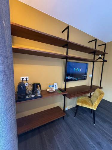 a room with a desk and a tv and a chair at Hotel Steeds aan Zee in Katwijk