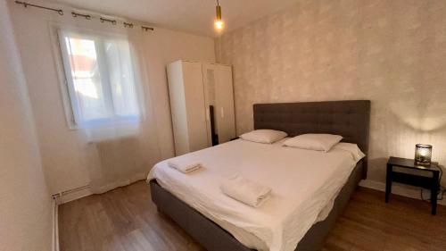 a bedroom with a bed with white sheets and a window at Europole 1 Gare de Grenoble & Centre Ville in Grenoble