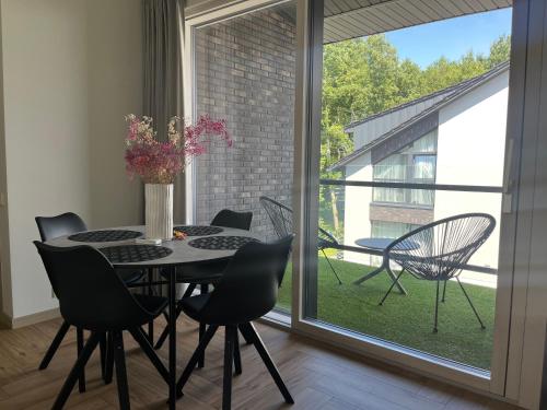 ein Esszimmer mit Tisch und Stühlen und einem Fenster in der Unterkunft MiMi Palanga - Self Check-in in Palanga