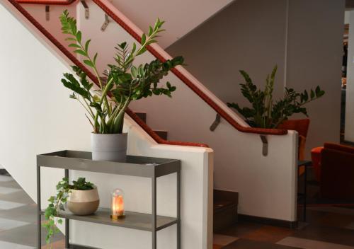 a staircase with a table with plants and a candle at Quality Hotel The Mill in Malmö