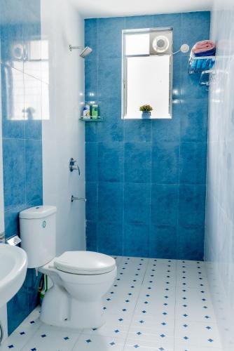 a blue bathroom with a toilet and a sink at Sea Breeze Goa in Talaulim