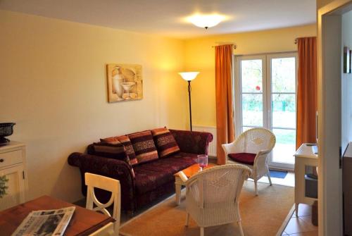 a living room with a couch and a table at Landhaus zum Strande - 44-6 1 in Kägsdorf