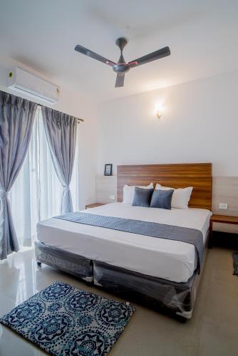 a bedroom with a large bed with a ceiling fan at Sea Breeze Goa in Talaulim