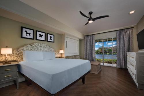 a bedroom with a large white bed and a window at Disney's Saratoga Springs Resort & Spa in Orlando