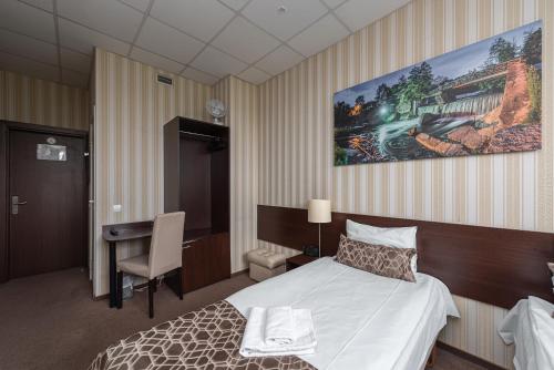 a hotel room with a bed and a desk at Vilnius City Hotel in Vilnius