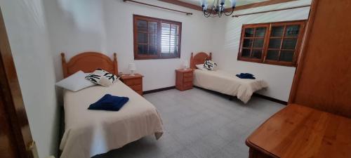 a bedroom with two beds and a table and window at Villa Lucía in Tías