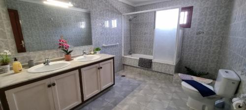 a bathroom with two sinks and a toilet and a mirror at Villa Lucía in Tías