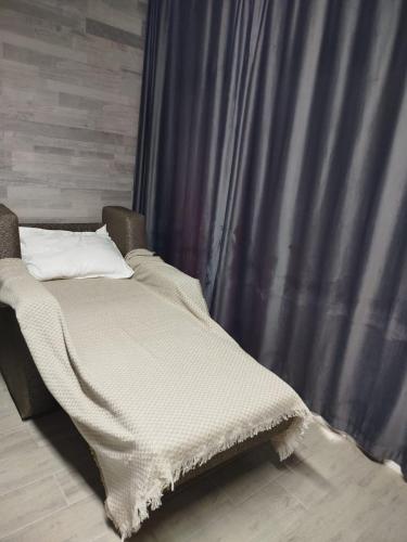 a bed sitting in front of a curtain at Ramgon in Gonio
