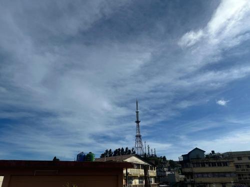 a tower on top of a building with a cloudy sky at The Mystic Mountain, rooms and Apartment in Kurseong