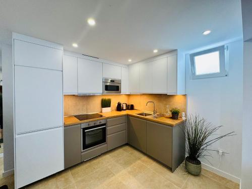 a kitchen with white cabinets and a sink at Bungalow Mesana 27 in Playa Honda