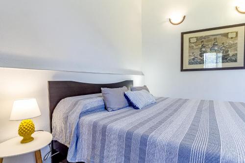 a bedroom with a bed with a blue striped bedspread at Mistral Guest House in Marina di Sorso