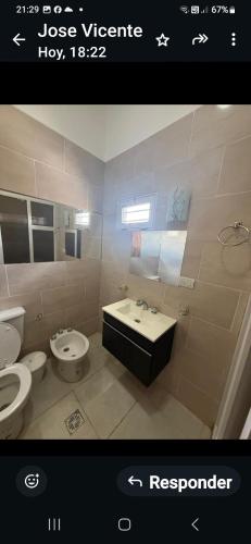 a bathroom with two toilets and a sink at Acordes de Gaitas dpto3 in Malargüe