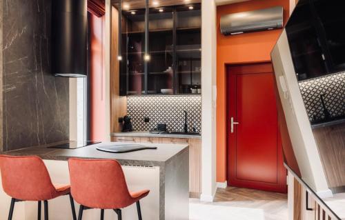 a kitchen with a red door and a table and chairs at 1 - Lisa Moderna - DonViore in Győr