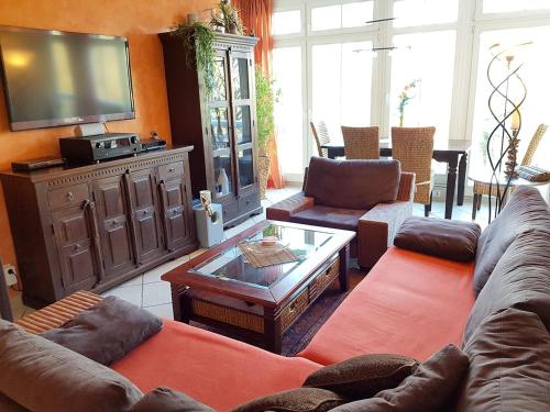 a living room with couches and a flat screen tv at Dünenschloss - 02-27 in Kühlungsborn