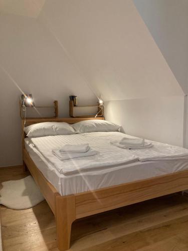 a bedroom with a large bed with white sheets at River Lodge Jesenica in Lička Jesenica