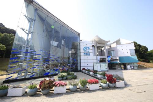 a building with a bunch of potted plants in front of it at Quintessa Hotel Sasebo in Sasebo