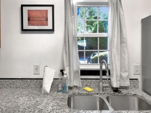 a kitchen counter with a sink and a window at Garden Level 1BR condo, Central Luxury Suite in Wilmington