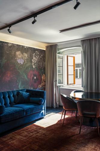 a living room with a blue couch and a table at Aiola Living Graz in Graz
