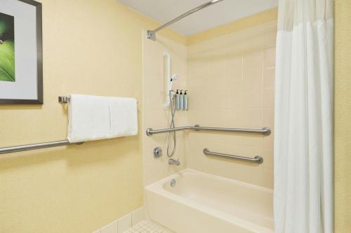 a bathroom with a tub and a shower with a shower curtain at Courtyard Des Moines West/Clive in Clive