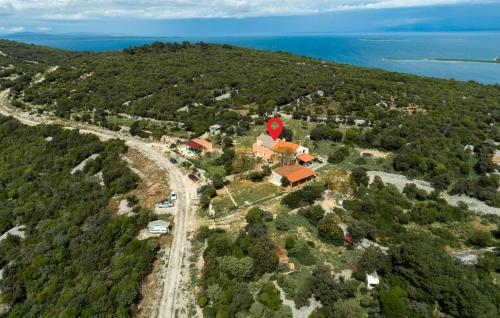 una vista aérea de una casa en una colina con el océano en Stunning Apartment In Veli Losinj With Wifi, en Veli Lošinj