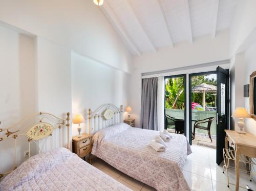 a bedroom with two beds and a balcony at Villaggio Maistro in Lefkada