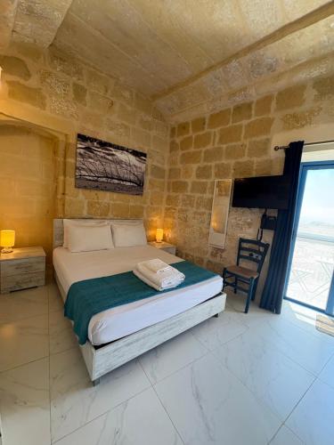 a bedroom with a bed and a large window at Fiftyfour West Boutique Living in Għarb