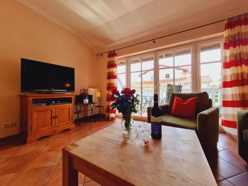 Sala de estar con mesa y botella de vino en Ferienwohnung Umberto, en Rerik