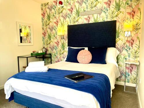 a bedroom with a large bed with a blue blanket at Gordons in Cheddar