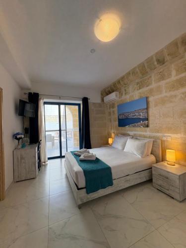a bedroom with a large bed and a large window at Fiftyfour West Boutique Living in Għarb