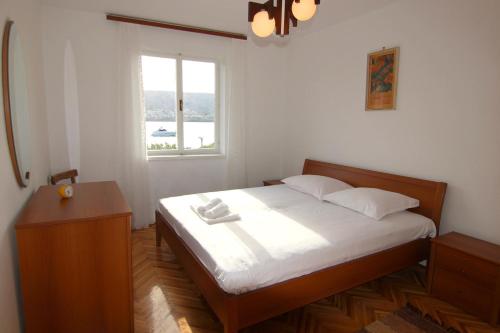 Un dormitorio con una cama y una ventana en By the sea apartment, en Pag