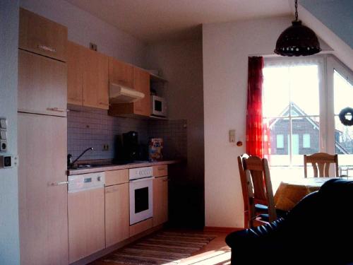 a small kitchen with a table and a window at Ferienwohnung Schwalbennest in Carolinensiel