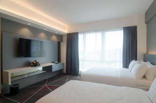 a hotel room with two beds and a flat screen tv at Amerin Hotel Johor Bahru in Johor Bahru