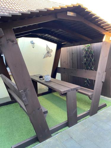 a wooden picnic table under a wooden roof at Hafenperle Carolinensiel in Carolinensiel