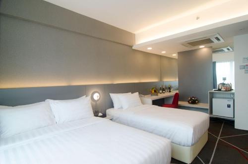 a hotel room with two beds and a kitchen at Amerin Hotel Johor Bahru in Johor Bahru