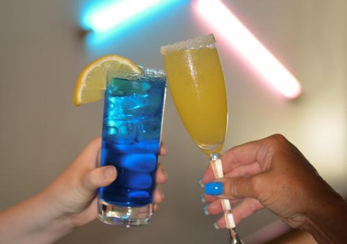 two people holding up two drinks in their hands at Quality Hotel The Mill in Malmö