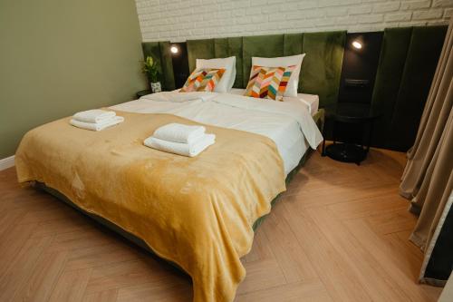a bedroom with a large bed with towels on it at Villa Botar in Cluj-Napoca
