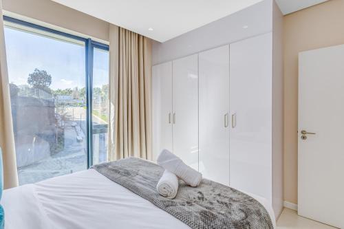 ein Schlafzimmer mit einem Bett und einem großen Fenster in der Unterkunft The Terrace101- 2 Bed, Sandton in Johannesburg