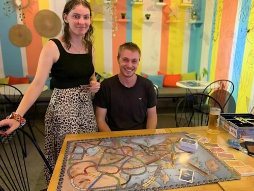 a man and a woman standing next to a table at THE PLACE Hostel Siem Reap Angkor in Siem Reap