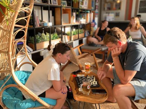 a couple of people playing chess in a library at THE PLACE Hostel Siem Reap Angkor in Siem Reap