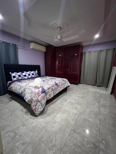 a bedroom with a bed in a room with purple walls at Serene 2 bedroom fully furnished house in Haatso