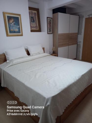 a bedroom with a large bed with white sheets at Casa De Giulio in Cocentaina