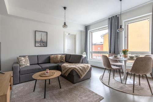 a living room with a couch and a table at Wallesmanni - Nokia Arena prime location apartments by Come in! in Tampere