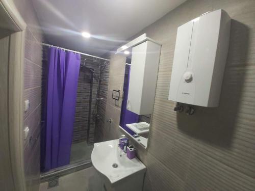 a bathroom with a sink and a purple shower at Apartmani Pelivan in Soko Banja