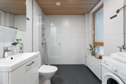 a white bathroom with a toilet and a sink at Wallesmanni - Nokia Arena prime location apartments by Come in! in Tampere