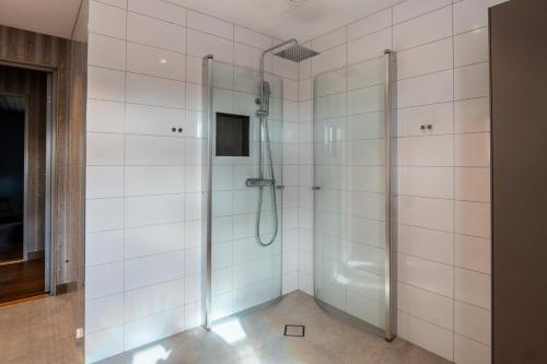 a bathroom with a shower with white tiles at Newly built house | Sauna | EV charger | Terrace in Lofsdalen
