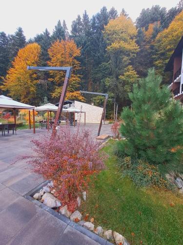 a park with a picnic shelter and trees in the background at Piatra Pinului Ski & Spa in Gura Humorului