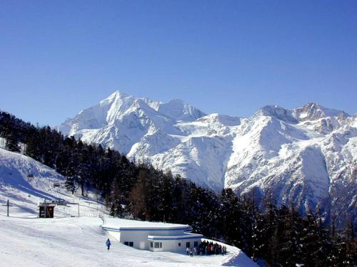 a snow covered mountain with a building on a ski slope at Ferienwohnung Edelweiss in Grächen