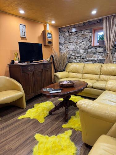 a living room with a couch and a table at Къща за гости Дени in Chukovezer