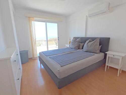 a large bed in a room with a large window at Villa Sunshine in Pissouri