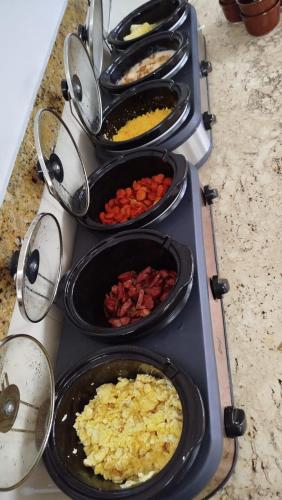 a stove top with many pans of food on it at Villa Mar Boa Viagem in Recife
